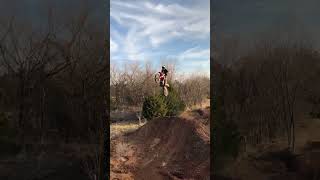 Guy rides dirt bike up ramp then hits his chest on handlebars