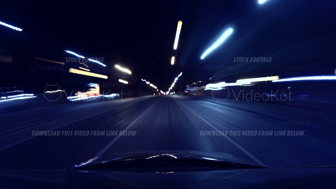 Fast car ride through city at night in rays of street lights, long ...