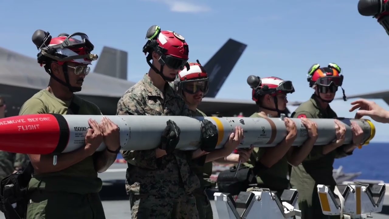 Загрузка боеприпасов, выполнение полетных операций и спуск на воду самолета "F-35B" на борту круп...