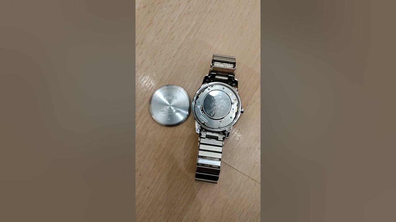 Trying to put a battery cover back on the back of an analog timex watch