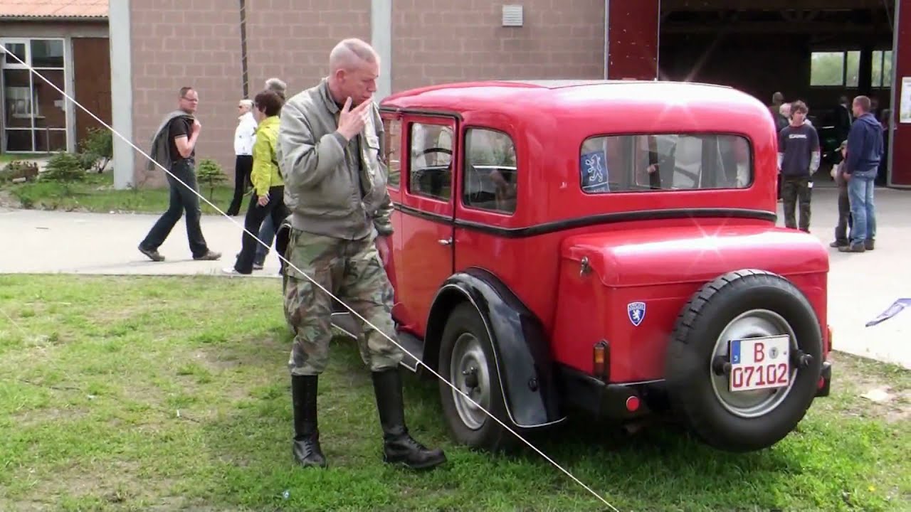 SMOKING IN BOOTS IN FRONT OF AN OLDTIMER
