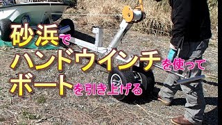 砂浜でハンドウインチを使ってボートを引き上げる