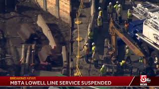Green Line extension heavy machinery blocking tracks for Lowell Commuter Rail train