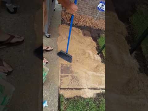 Pushing sand into patio pavers add stability and improves drainage for a stronger patio