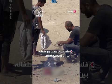 فلسطيني وأطفاله يبحثون عن الطحين في رمال غزة