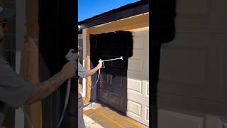 Applying Black Paint To A Garage Door Using A Spray Gun