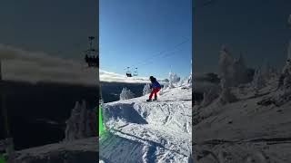 Snowboarder attempts to jump ledge then crashes into wooden fence and flips forward