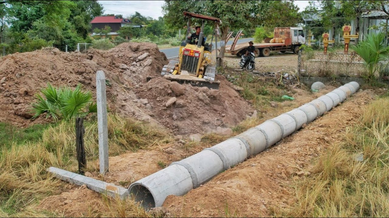 Clearing soil to bury a long 12 m drainage next to the road. Drivers passing by must be very careful