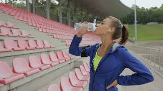 Athletic Fitness Woman Take A Break And Drink Water At The Stadium