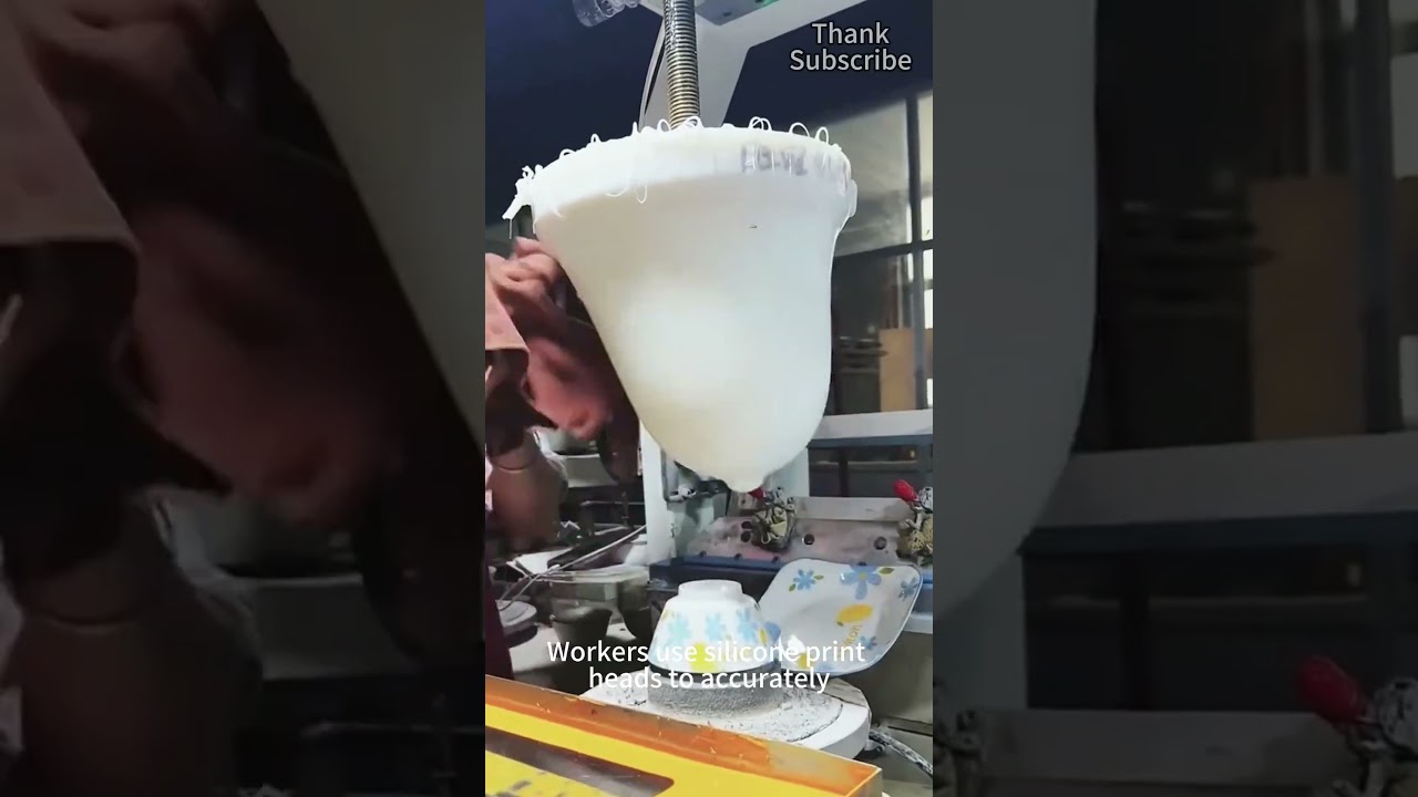 Рабочие используют силиконовые печатающие головки для точной печати узоров на керамической посуде.