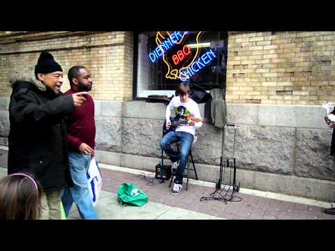 Galen playing guitar on the street corner