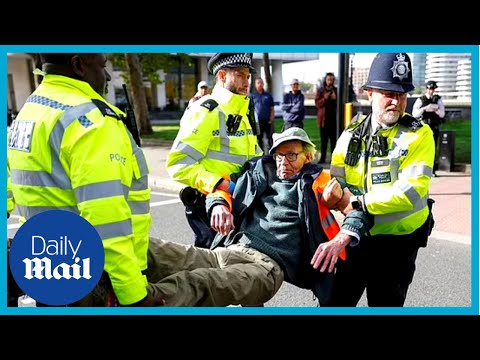 Police struggle to carry away just stop oil activists out of road