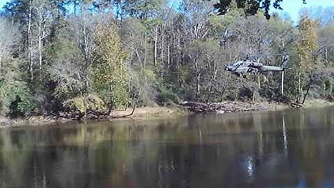 Boeing AH-64 Apache helicopter low pass #1 over river.