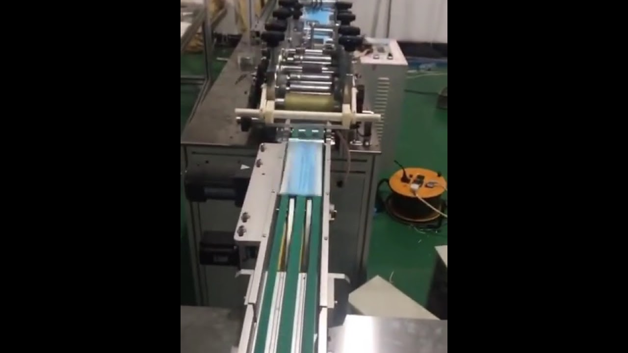 El estudiante embroma la máscara del lazo del oído del bebé que hace la línea de producción de la má