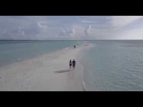 Couple Walking on a Beach Filmed with a Drone leaving footprints