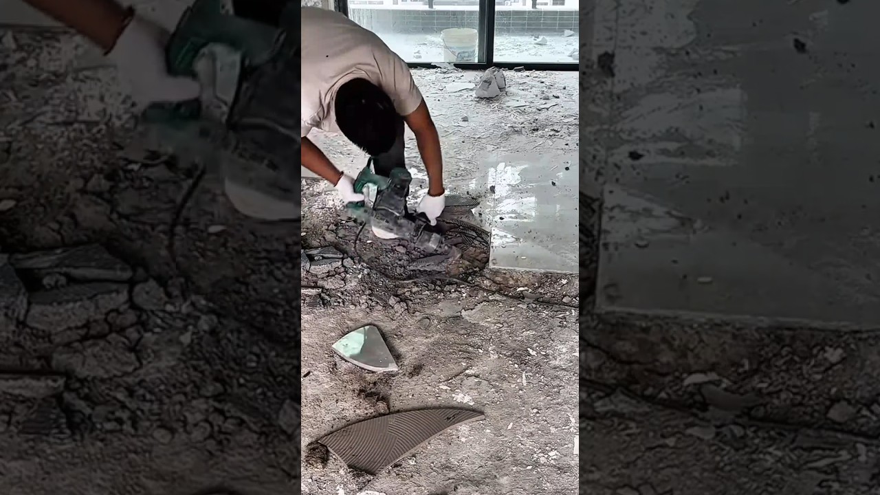 A Demolition Worker Using a Heavy-Duty Electric Jackhammer to Break Up Old Ceramic Floor Tiles