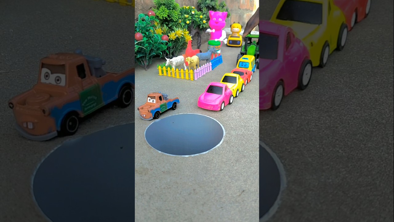 Big tractor pushing pink yellow red and cartoon bus car in pit 