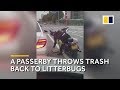 A passerby throws trash back into a litterbug’s car