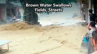 Brown Water Swallows Fields, Streets and a Historic Wooden Bridge