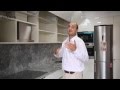 Video de cocinas integrales modernas blancas con tirador pestaña y encimera silestone