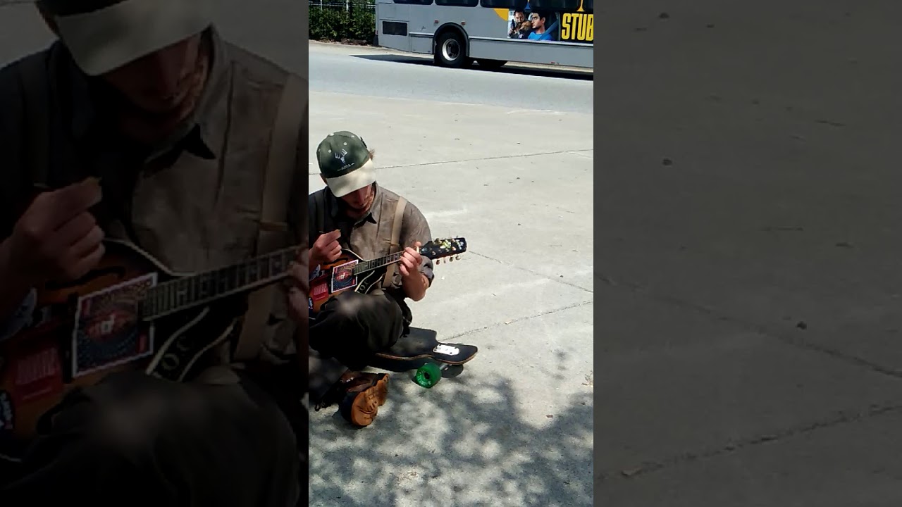 Local boy playing guitar at bus stop,canada,bc