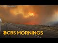 California wildfire explodes as storm threatens mudslides in southern part of state