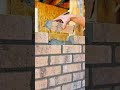 Applying mortar and laying bricks with a trowel for a wall construction project at a workshop