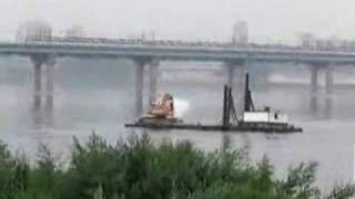 An excavator paddling a barge