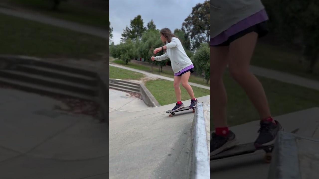 Girl rides skateboard down ramps at skatepark then falls and lands on back