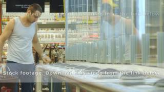 Guy Coming Up To The Fridge In Shop And Taking Product From It