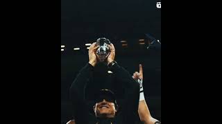 Jim Harbaugh and Aiden Hutchinson raising that Championship trophy.