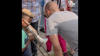 Trombone Shorty gives child music lesson at Art Neville's second line
