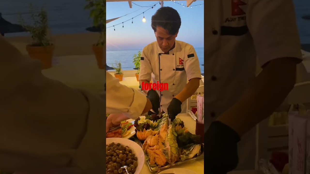 cutting whole salmon .(wedding party at beach restaurant )@A