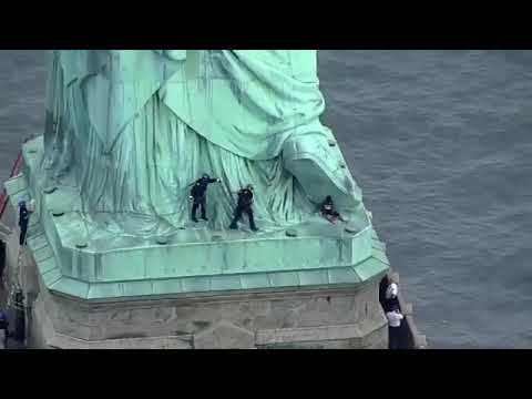 Mujer protesta escalando Estatua de la Libertad - Mujer protesta escalando Estatua de la Libertad