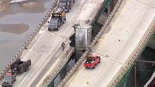 UPS truck dangles from bridge after driver loses control