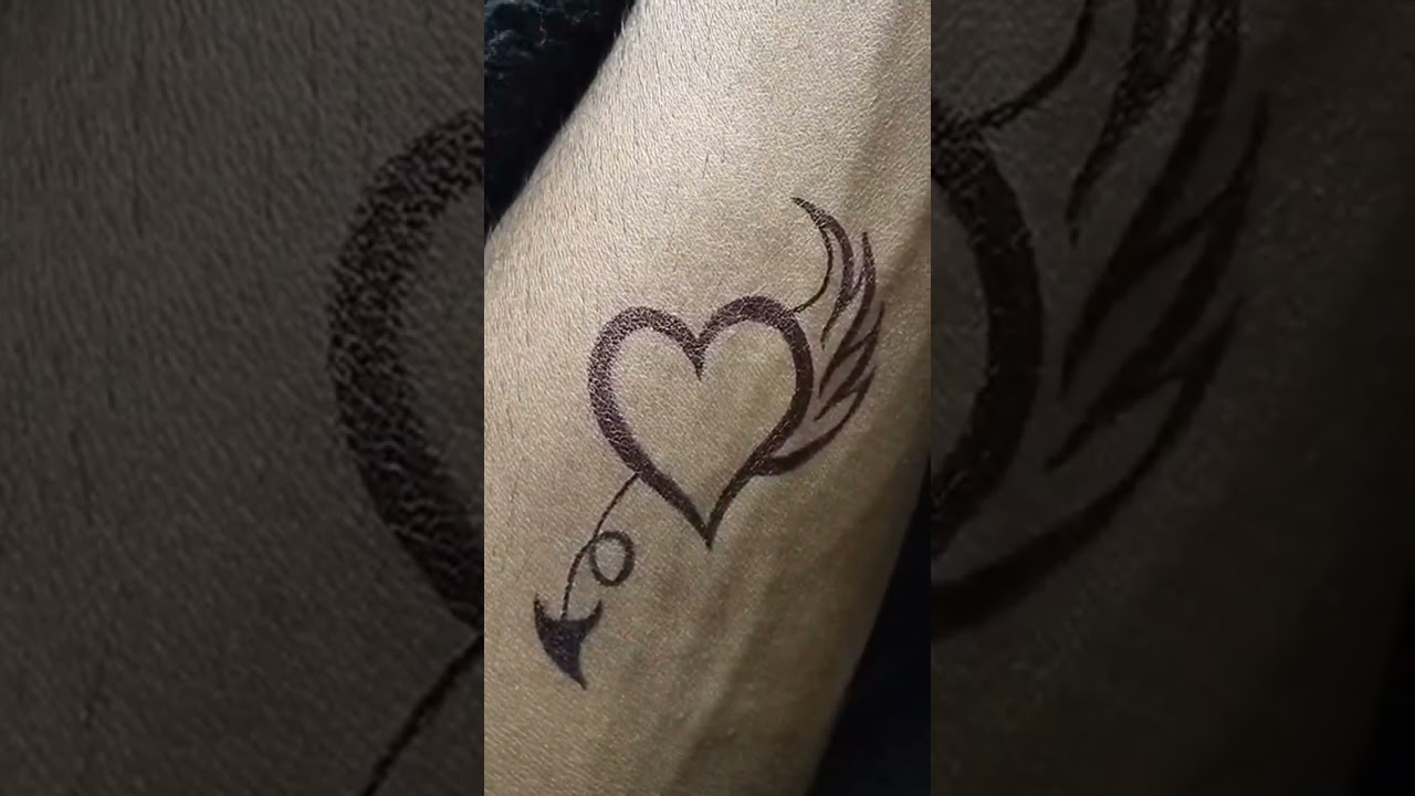 heart with flying tattoo with pen