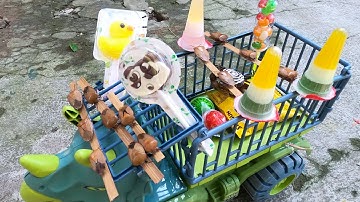 Thảo Cady kéo xe nhặt bánh kẹo và các con vật trong sân, con cua, cá heo, con rùa, thach dâu tây, cá