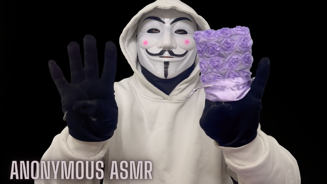 Anonymous Figure In White Hoodie Examines Purple Bag Object