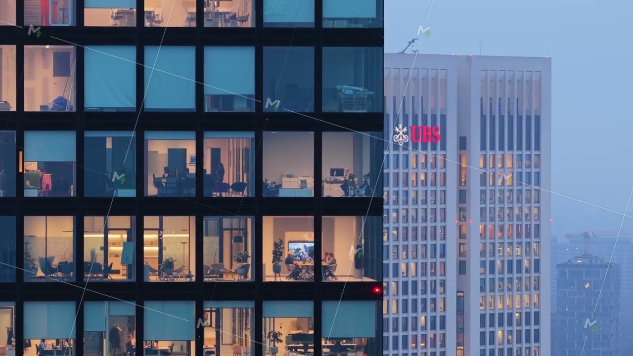 Aerial view of a modern office building with employees working after sunset, UBS bank skyscraper in