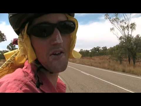Road train cattle truck passes cyclist bike rider in Australian outback.. Queensland Australia