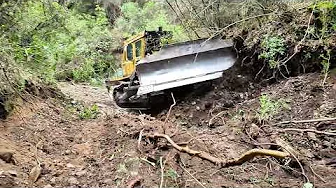 FOREST ROAD CONSTRUCTION WORK FROM DOZER-BOTTOM POINT OF THE DENSE ROCK AND  FOREST Caterpillar D7G
