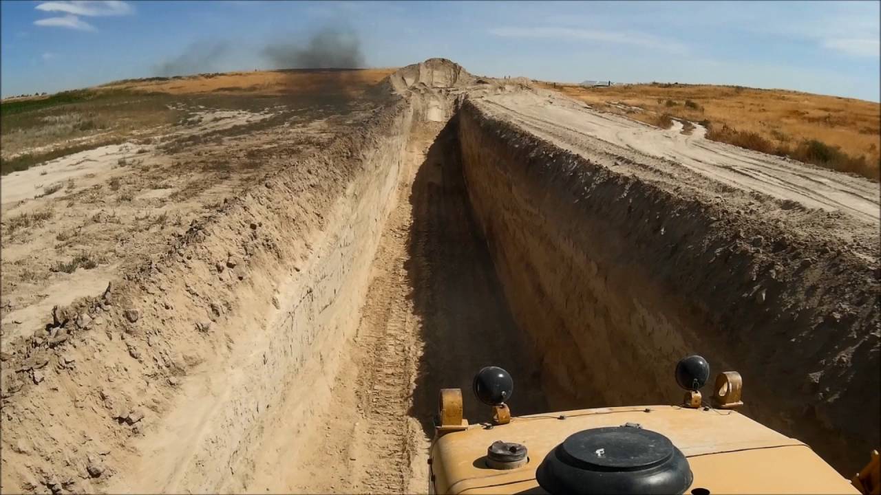 D9G digging a deep slot trench