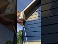Painting house exterior walls blue with a sprayer machine