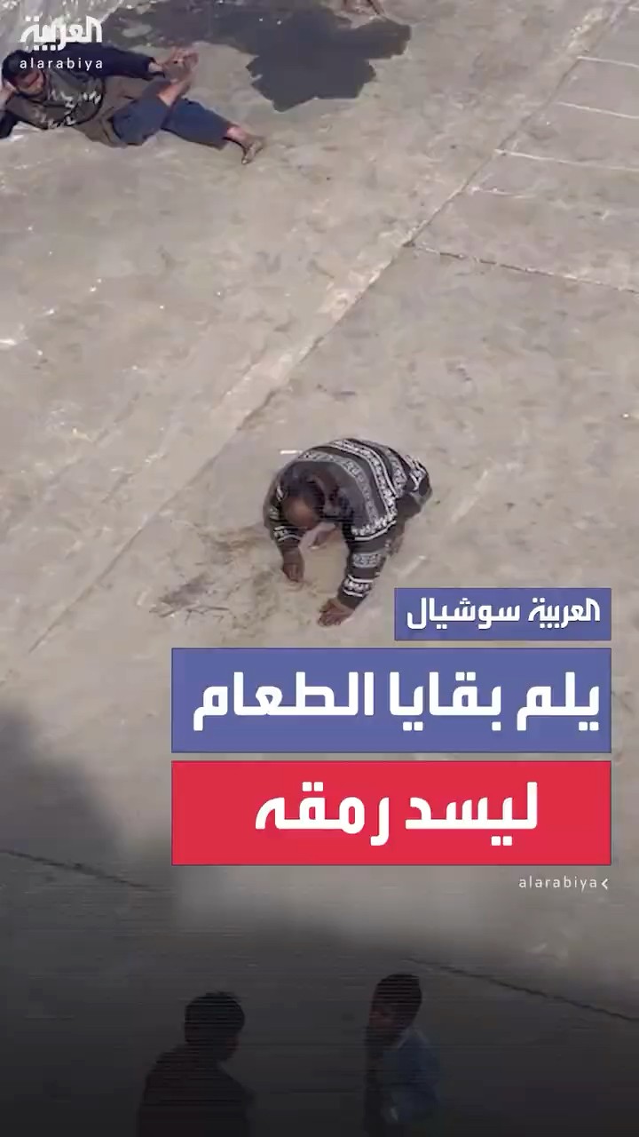 فلسطيني يلم بقايا الطعام عن الأرض ليسد بها رمقه في أحد مراكز الإيواء بقطاع غزة