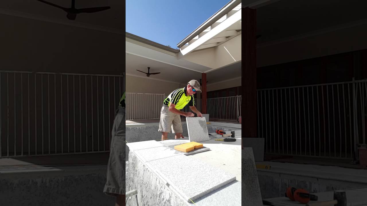 Laying granite coping tiles on pool