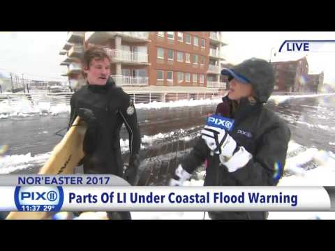 Surfer hits the beach during snowstorm