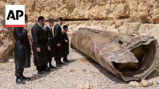 Jewish Ultra-Orthodox families inspect debris of what's believed to be an intercepted Iranian surfac