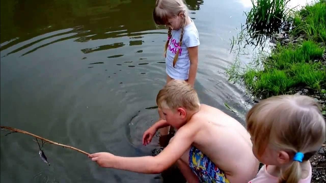 Детка ловли лав. Дети ловят рыбу. Поймал маленькую рыбку. Мальчик ловит рыбу с палкой. Дети ловят рыбу в лагере.