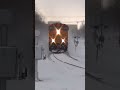 BNSF train plows through big snow drifts.