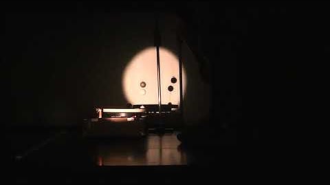 Ball on turntable rotates beneath synchronized pendulum